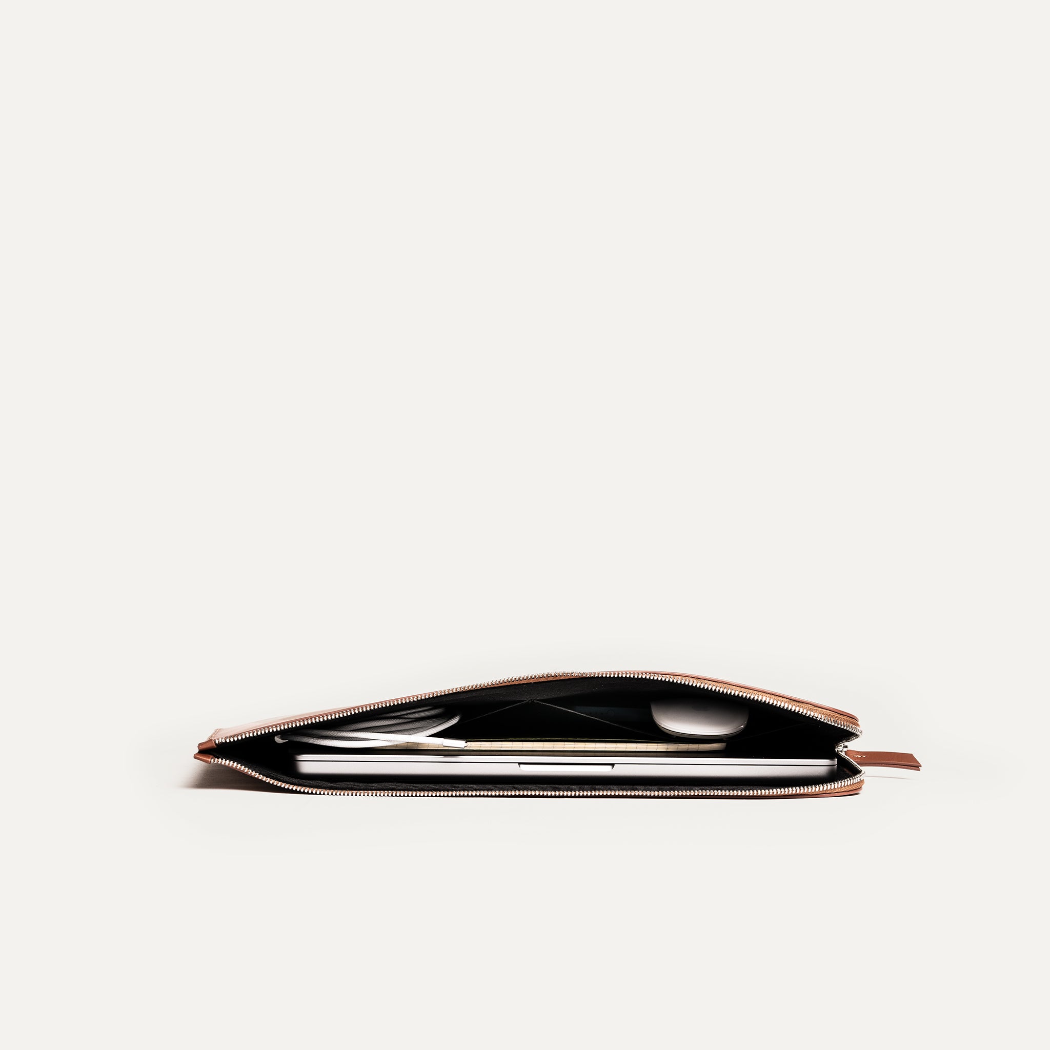 Découvrez la pochette pour ordinateur portable en cuir minimaliste, parfaite pour les professionnels modernes. Fabriquée en cuir marron de haute qualité, elle offre une protection durable. Son design épuré et élégant s'adapte à tous les styles. 