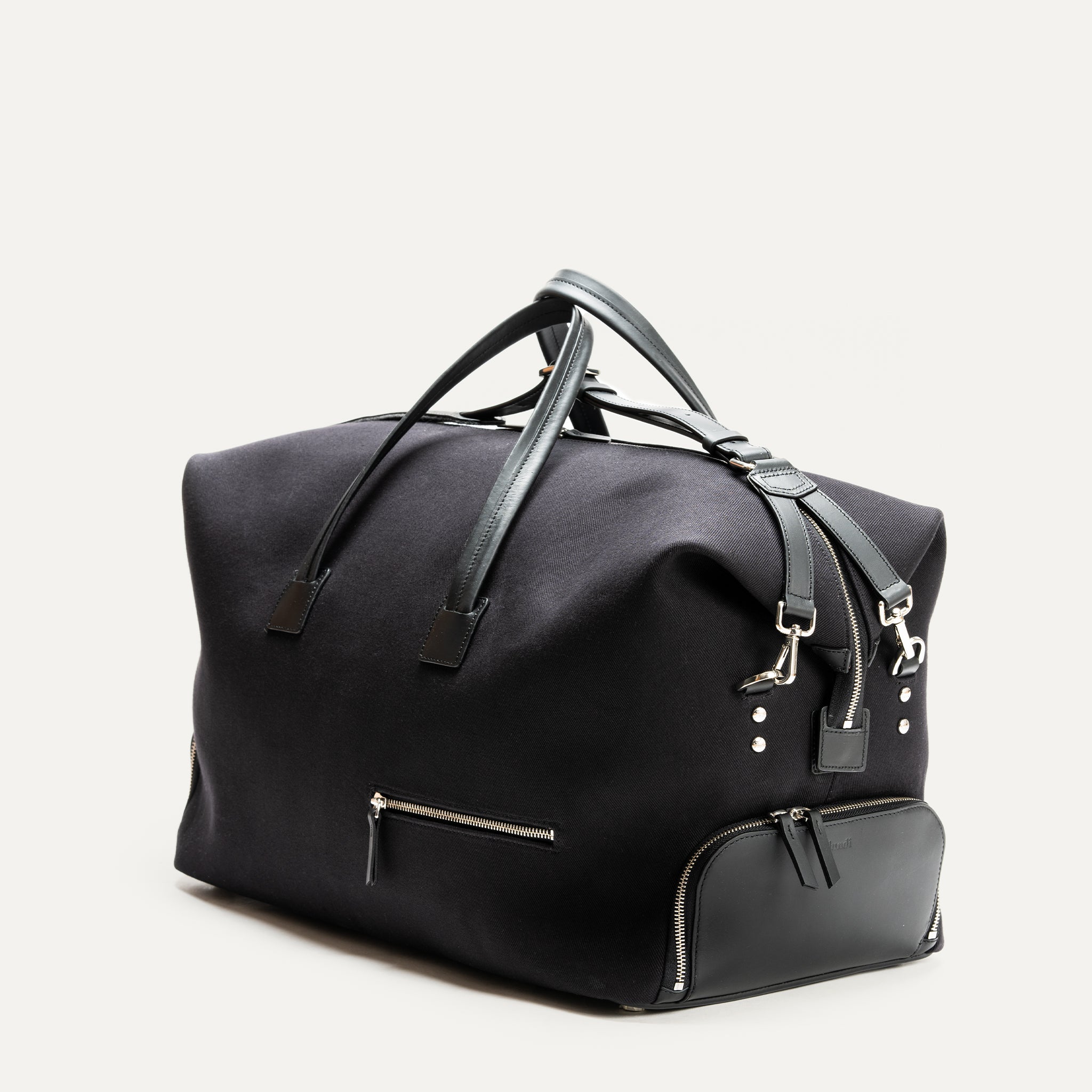 Découvrez ce sac de voyage en toile accentué par des détails en cuir de haute qualité. Il est parfait pour les escapades de week-end, offrant un grand espace de rangement et des poches zippées pour une organisation optimale. Son design chic en font un compagnon de voyage indispensable.