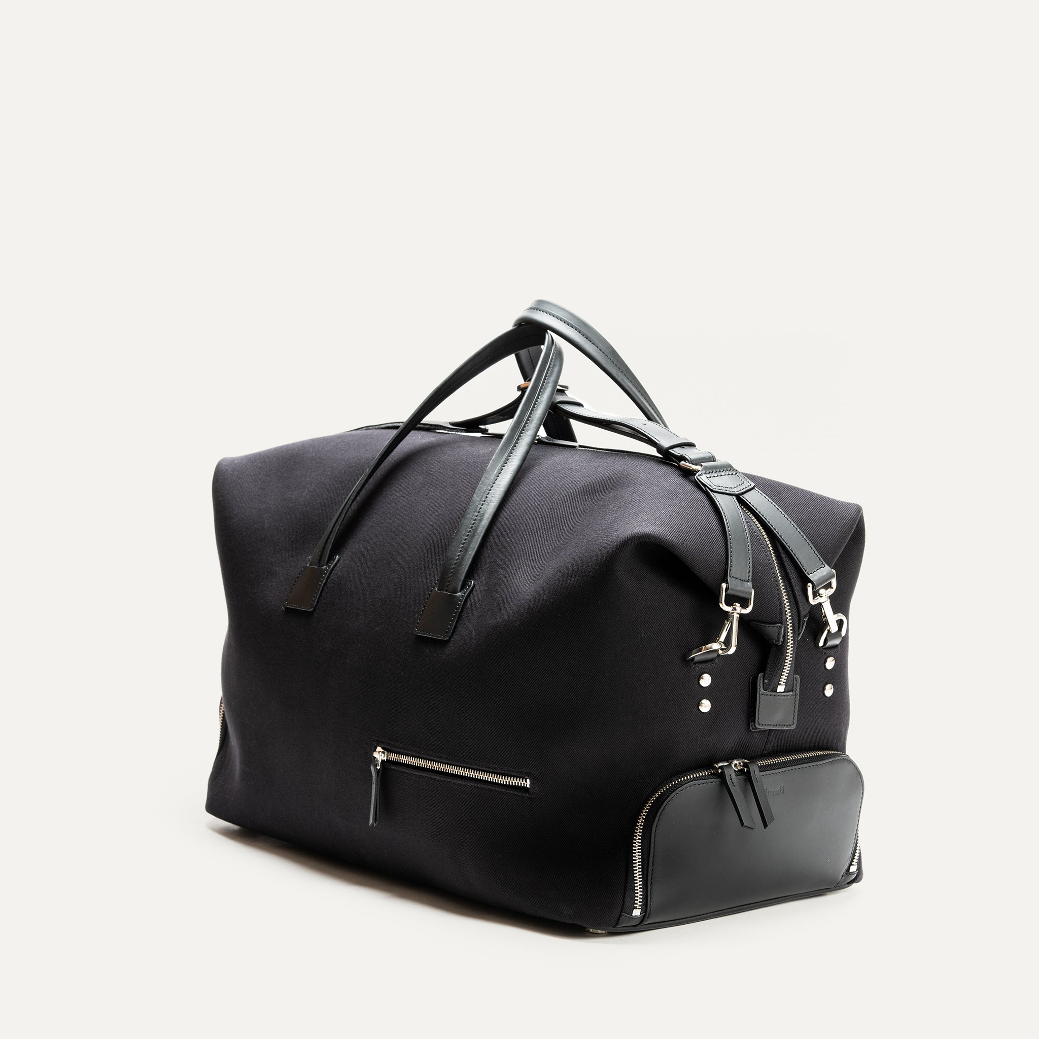 Voyagez avec classe grâce à ce sac de voyage noir en toile résistante. Il est équipé de poignées en cuir et de poches extérieures zippées pour une organisation facile. Son design épuré et fonctionnel le rend idéal pour tous vos déplacements, offrant un espace de rangement suffisant pour tous vos essentiels de voyage.