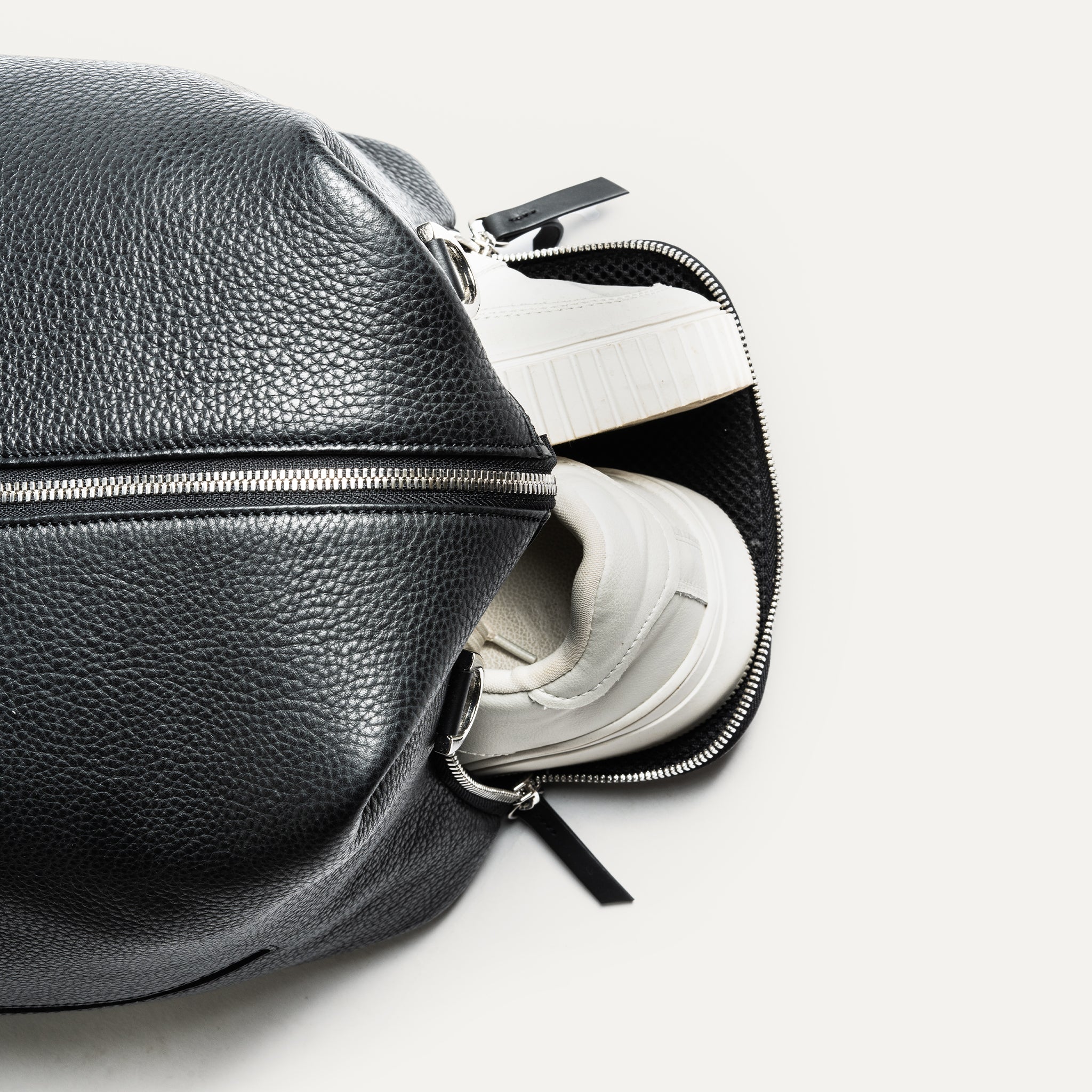 Parfait pour les escapades de week-end, ce sac de voyage en cuir noir est compact mais spacieux. Il comprend une poche pour ordinateur et des poches pour accessoires. Les poches extérieures permettent de ranger chaussures ou linge sale. Un sac élégant et pratique pour toutes vos aventures.