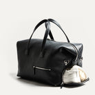 Ce sac de voyage en cuir noir est suffisamment compact pour vous accompagner en toutes circonstances, et suffisamment spacieux pour y loger l’essentiel de vos affaires pour quelques jours de voyage. Il inclut un espace pour vos affaires de bureau, avec une poche pour ordinateur et diverses poches pour accessoires.