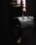 Compact et spacieux, ce sac de voyage en cuir noir est parfait pour un usage quotidien et les voyages courts. Il comprend une poche pour ordinateur et des poches pour petits accessoires. Les poches extérieures sont idéales pour ranger chaussures ou linge sale. Un choix élégant et pratique.