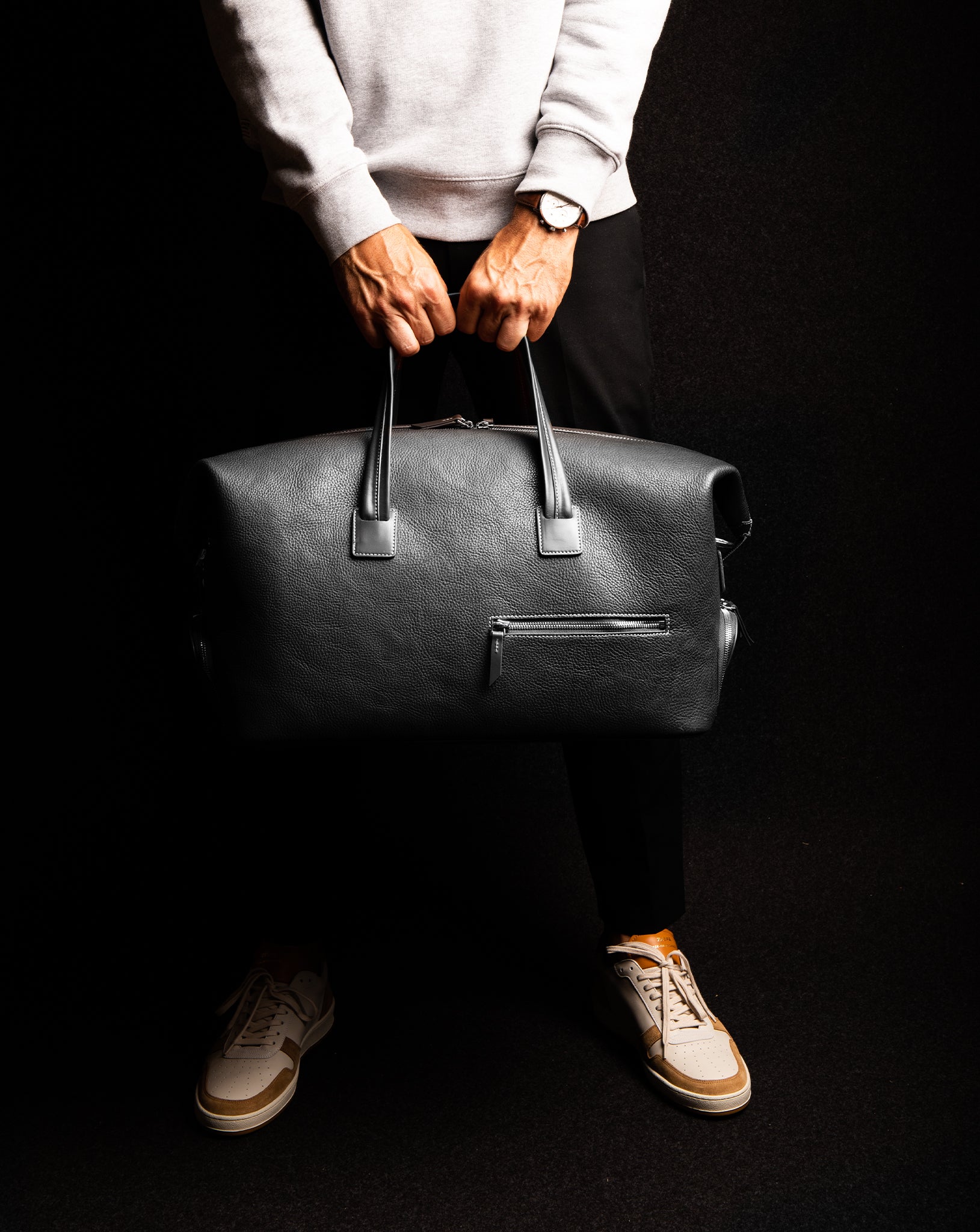 Ce sac de voyage en cuir noir est conçu pour les professionnels en déplacement. Il offre un espace dédié pour les affaires de bureau, y compris une poche pour ordinateur et des poches pour accessoires. Les 2 poches extérieures permettent de ranger chaussures et trousse de toilette. Un choix élégant et pratique pour les voyages.